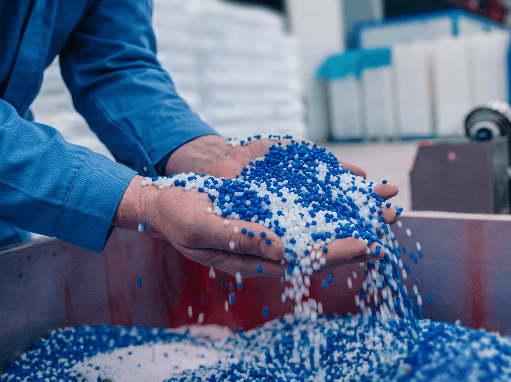 Grânulos plásticos reciclados sendo manuseados na produção